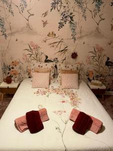 um quarto com uma cama com papel de parede floral em Le moulin de la Vernoelle em Prémilhat