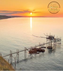 a group of boats sitting in the water at sunset at Villa Marianna in Vasto