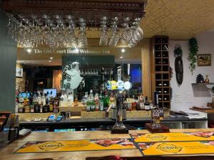 a bar with a counter with bottles of alcohol at The Old Court Hotel in Witney