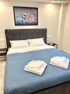 a bed with two white towels on top of it at Agorakritou Magic Corner in Athens