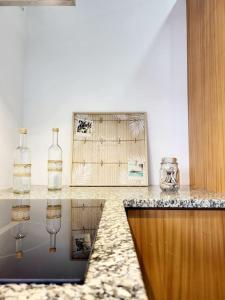 um balcão com garrafas de vidro e uma fotografia em A Casa da Concha em Rabo de Peixe