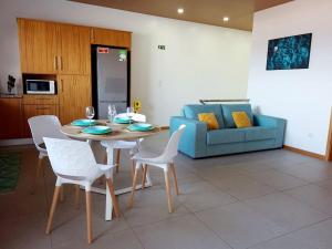 a living room with a table and chairs and a couch at A Casa da Concha in Rabo de Peixe