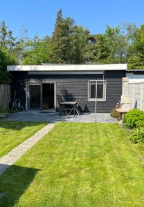 a black shed with a picnic table in a yard at Rustig gelegen recreatiewoning in Zeeland in Bruinisse