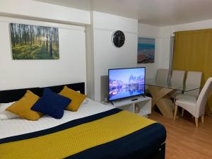 1 dormitorio con 1 cama y TV de pantalla plana en London Stratford 4 Bedrooms Apartment, en Londres