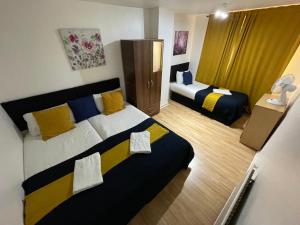 pokój z 2 łóżkami w pokoju hotelowym w obiekcie London Stratford 4 Bedrooms Apartment w Londynie