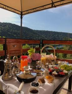 a table with food and drinks on it with a view at Holiday Home Aladin's in Bihać