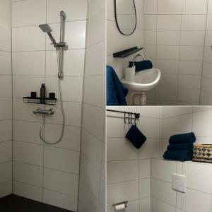 La salle de bains blanche est pourvue d'une douche et d'un lavabo. dans l'établissement B&B Twente, à Enschede