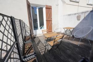 een balkon met stoelen, een tafel en een raam bij T3 Appart Cosy avec Terrasse proche Loire in Orléans