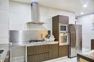 a kitchen with a stove and a refrigerator at Impeccable 3-Bed luxury Apartment in ikoyi Lagos in Lagos