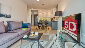 salon z kanapą i telewizorem w obiekcie Rezydencja Niechorze 328 - 5D Apartamenty w mieście Niechorze