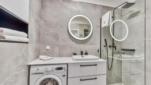 W łazience znajduje się pralka i lustro. w obiekcie Rezydencja Niechorze 328 - 5D Apartamenty w mieście Niechorze +19 zdjęć