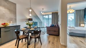 kuchnia i salon ze stołem i krzesłami w obiekcie Rezydencja Niechorze 328 - 5D Apartamenty w mieście Niechorze
