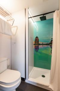uma casa de banho com um WC e uma cabina de duche em vidro. em Hotel AtypiQ em Cidade de Quebec