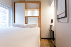 a bedroom with a bed with two pillows on it at Hotel AtypiQ in Quebec City