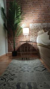 a bedroom with a brick wall and a table with a lamp at La Sal Home Toledo in Toledo