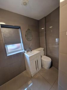 a bathroom with a toilet and a sink and a window at LaLuNa One Bedroom Apartment Newcastle in Elswick