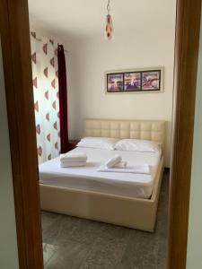 ein Schlafzimmer mit einem Bett mit zwei Handtüchern darauf in der Unterkunft Quartz Apartament in Durrës