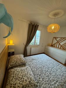 een slaapkamer met een bed en een kroonluchter bij Maison port guillaume in Dives-sur-Mer +21 foto's