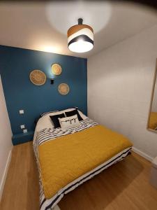a bedroom with a bed with a yellow blanket at Gîte du moulin Mont Saint Michel in Pontorson