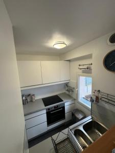 een kleine keuken met een fornuis en een spoelbak bij Maison port guillaume in Dives-sur-Mer