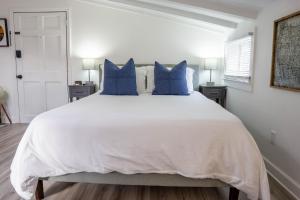 um quarto com uma grande cama branca com almofadas azuis em Carriage on Capital near Distilleries & Downtown em Frankfort