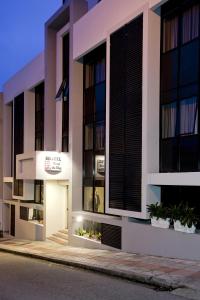 a facade of a building with black shuttered windows at Hotel Farol da Ilha in Florianópolis