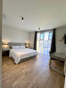 um quarto com uma cama e uma grande janela em Capital Suites em Chilpancingo 
