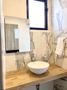 La salle de bains est pourvue d'un lavabo blanc sur un comptoir en bois. dans l'établissement Capital Suites, à Chilpancingo 