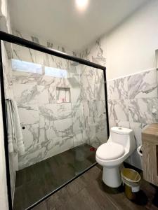 a bathroom with a toilet and a glass shower at Capital Suites in Chilpancingo  +13 photos