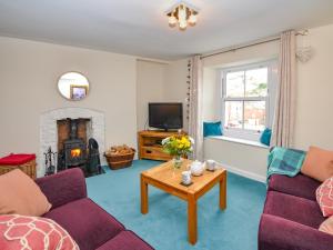 a living room with two purple couches and a fireplace at 2 bed in Brixham 77769 in Brixham