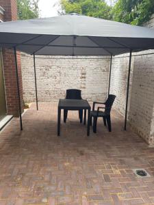 a black tent with a table and a chair under it at 133 Cornwall Road n15 5ax in London