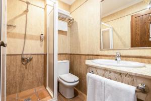 ein Bad mit einem WC, einem Waschbecken und einer Dusche in der Unterkunft Hostal La Muralla in Zahara de los Atunes