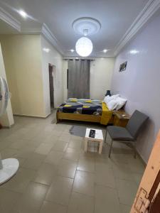 a bedroom with a bed and a table and a chair at Grand Yoff in Ziguinchor