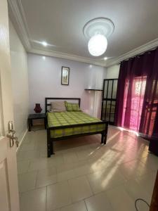 a bedroom with a bed in the middle of a room at Grand Yoff in Ziguinchor