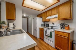 eine Küche mit weißen Geräten und Holzschränken in der Unterkunft Family Friendly and quite 2 bedroom Condo Close to Fun in Fort Wayne