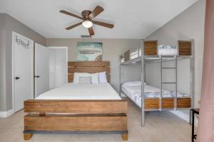 a bedroom with two bunk beds and a ceiling fan at Overlooking Lagoon and Pool-Free Golf Cart-Kayaks in Key Largo