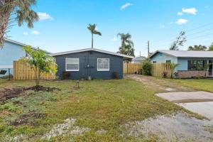 a blue house with a fence and a yard at Downtown Punta Gorda 3 bd Bungalow in Punta Gorda