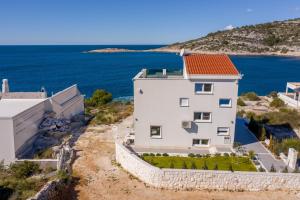 an aerial view of a white building with an orange roof at Villa Esquel - Beachfront, heated pool in Ražanj