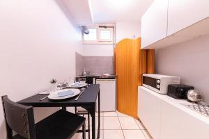a small kitchen with a table and a microwave at Zen Lyon - Jacuzzi et Sauna - Lyon 8ème in Lyon