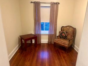 - un salon avec une chaise et une fenêtre dans l'établissement Fully furnished garden apartment, à Savannah