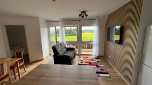 a living room with a chair and a table at Allgäuhaus Thomas am Bauernhof Ferienwohnung in Wald