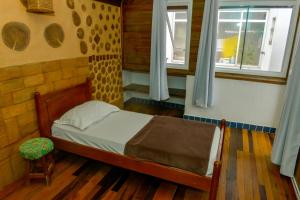 a small bedroom with a bed and a window at Verde Vida Ecopousada - Termas do Gravatal in Gravatal