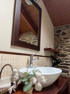 ein Badezimmer mit einem weißen Waschbecken und einem Spiegel in der Unterkunft Casa Rural Dona María in Ordes