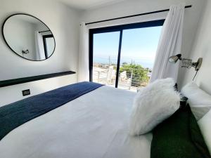 a bedroom with a bed with a mirror and a window at Ocean View Villa - Upper in St. Helena Bay