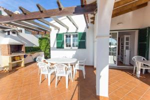 un patio con una mesa blanca y sillas blancas en Villa Anita, en Santo Tomás