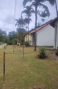 une cour avec des palmiers devant un bâtiment dans l'établissement Pousada Porto Aventura -Chalés da Luci, à Peruíbe