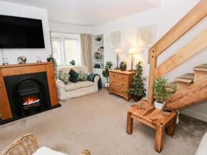 a living room with a fireplace and a tv at Fleece Cottage in Holmfirth