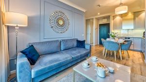 un soggiorno con divano blu e tavolo di Rezydencja Niechorze 314 z Widokiem na Morze - 5D Apartamenty a Niechorze
