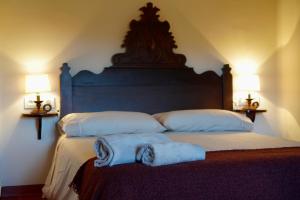 1 dormitorio con 2 toallas en una cama con 2 lámparas en L'Hostatgeria, en Estany