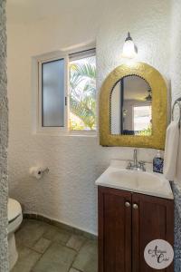 uma casa de banho com um lavatório, um espelho e um WC. em Antigua de Cabo em Cabo San Lucas